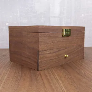 Close-up detail of the double-layer wooden storage box showing the golden clasp and knob.