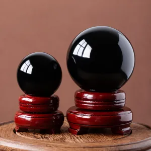 Natural obsidian crystal sphere set with wooden base for home office decor feng shui display.
