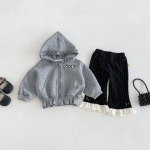 Detailed view of baby girl casual grey hoodie and black polka dot flared pants clothing set.
