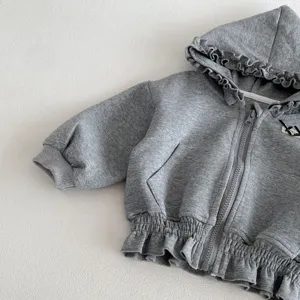 Close-up detail of toddler grey hoodie, featuring cute ruffles and soft knit fabric.