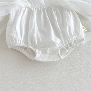Infant baby white romper dress detail close up, soft cotton fabric with mesh tutu skirt.