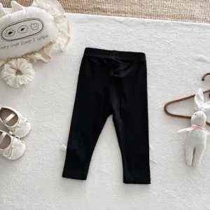 Detailed view of black ribbed baby leggings, high elasticity, comfortable toddler long pants.