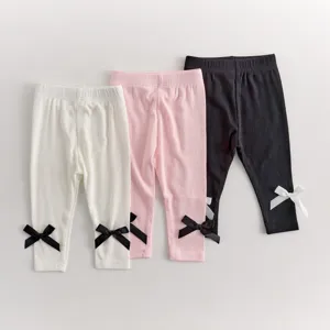Detailed view of baby elastic leggings featuring cute bow knots at cuffs in multiple colors.