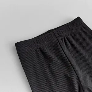 Close-up view of black ribbed baby leggings waistband, showing soft elastic fabric details.