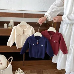 Baby knitted cardigan jacket detail, featuring lapel collar, zip-up front and dual pockets.