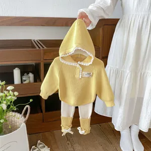 Toddler knit set detail showcasing the yellow hooded sweater with lace trim and leggings.