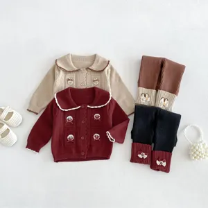 Detailed view of baby knit cardigan and stitched leggings set with cute bows and buttons.