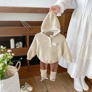 Detailed view of toddler knit hooded sweater, leggings and socks set in warm beige and brown tones.