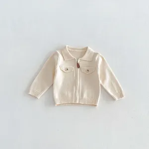 Infant knitted cardigan detail view, baby zipper sweater with lapel and pockets in neutral beige tone.