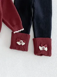 Baby knit cardigan and leggings set detail, featuring cute bow lace cuffs for autumn style.