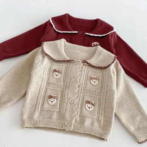 Detailed view of cute toddler knitted cardigan with sweet bear appliques, lapel collar and buttons.