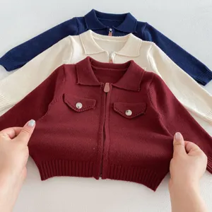 Infant knit cardigan detail view, showing soft fabric texture, zipper and pocket features.