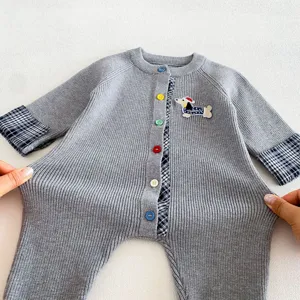 Detailed close-up view of grey knitted baby romper featuring colorful buttons and cute dog patch.