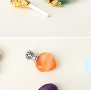 Vue détaillée du pendentif flacon de parfum en cristal naturel en forme de cœur et capuchon.