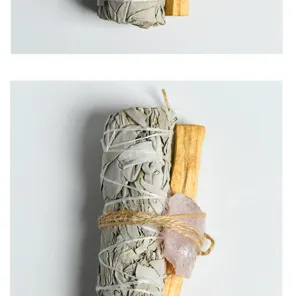 Close-up detail view of white sage bundle, palo santo stick, and raw rose quartz crystal.