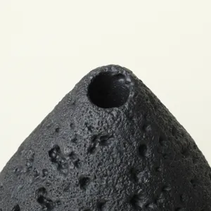 Quemador de incienso cráter lunar negro primer plano, soporte aroma piedra cerámica.