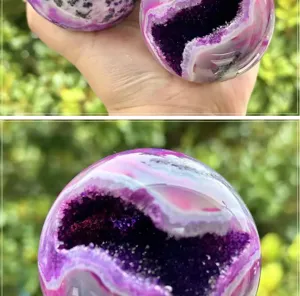 Close-up detail shot of polished natural purple moss agate crystal ball geode ornament.