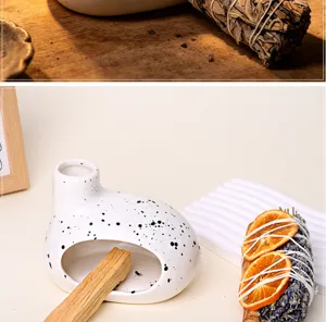 Ceramic incense burner set with palo santo and dried sage bundle for home relaxation.