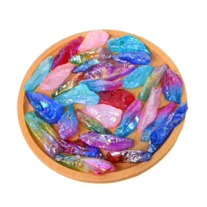Pierres de quartz cristal brutes galvanisees colorees sur plateau en bois rond.