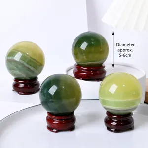 Natural green fluorite crystal sphere with wood base for home office feng shui decor.