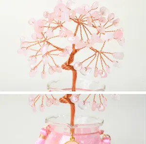 Close up view of handmade rose quartz crystal money tree with copper wire and glass jar detail.