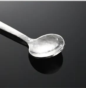 Gros plan détail d'une cuillère miniature en titane pur pour sel et café avec une belle texture.