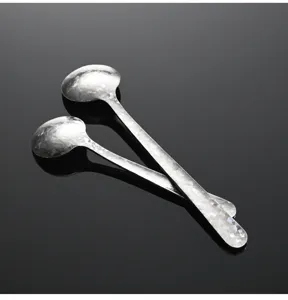 Vue détaillée de mini cuillères en titane cristallin, texture élégante de sel.