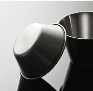 Détail de tasse à sauce en acier inoxydable montrant une finition métallique et texture.