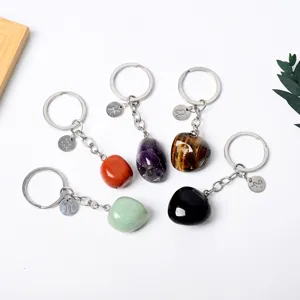 Detailed view of natural crystal tumbled stone keychains featuring zodiac pendant charms.
