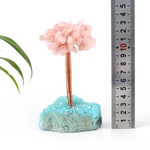 Close-up detail of handmade crystal tree with pink quartz leaves and blue cluster base.