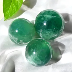 Natural green fluorite crystal ball ornament, polished raw gemstone energy sphere for home decor.