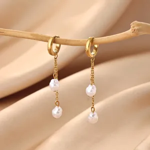 Gold stainless steel hoop earrings with baroque pearl dangles, elegant vintage jewelry detail.