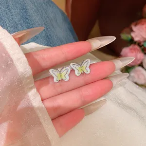 Gros plan sur les détails de boucles d'oreilles papillon en argent au design délicat.