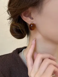 Vintage amber stud earrings detail shot, elegant round design showcasing exquisite texture.