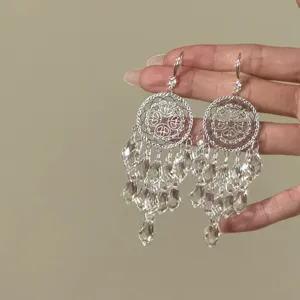 Exquisite dreamcatcher crystal tassel earrings detail shot, elegant silver jewelry accessory.