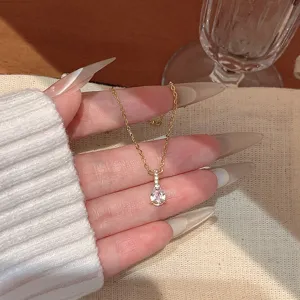 Detailed view of the delicate gold teardrop zircon necklace, minimalist chic clavicle chain.