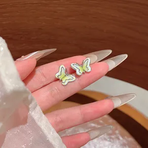 Close-up detail of double-layer butterfly stud earrings featuring color-blocked enamel design.