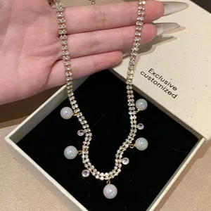 Detailed shot of Korean style double strand rhinestone necklace with pearl charms and pendants.