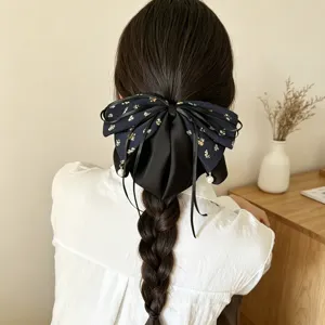 Detailansicht einer retro Blumen Schleife Haarspange mit Perlen Anhänger, eleganter Haarschmuck.