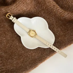 Detail shot of the elegant polygon dial women quartz watch with white leather strap.