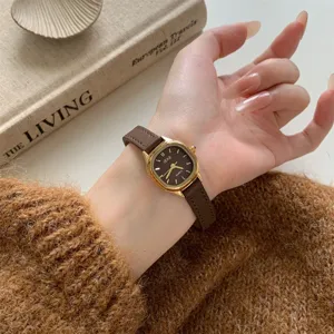 Women's quartz watch with brown leather strap, gold polygon dial, and elegant retro design.