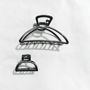 Primo piano dettagliato delle pinze per capelli geometriche in metallo, due misure.