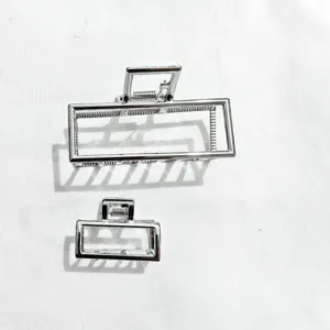 Dettaglio molletta capelli geometrica rettangolare in metallo argentato, set elegante.
