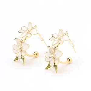 Eleganti orecchini fiori smalto bianco dorati, delicato design con dettagli floreali.