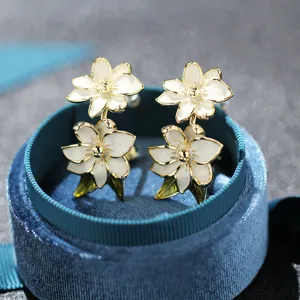 Eleganti orecchini a lobo fiori bianchi placcati oro con design goccia d'olio per donna.