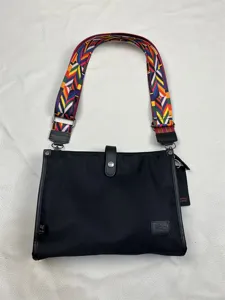 Stylish black nylon crossbody bag with colorful geometric woven strap, casual shoulder bag.