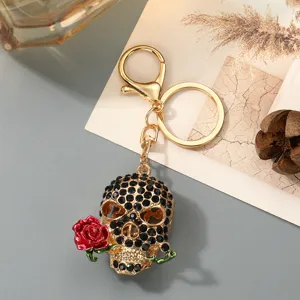 Detailansicht des Strass-Totenkopf-Schlüsselanhängers mit roter Rose und goldenem Metallbeschlag.