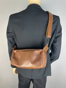 Detailed back view of the vintage brown leather crossbody bag with wide strap and hardware.