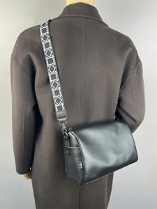 Vue détaillée du sac bandoulière souple pour homme avec large sangle à motif géométrique.
