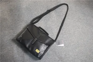 Dettaglio della borsa messenger aziendale nera in pelle PU con patta e tracolla regolabile.